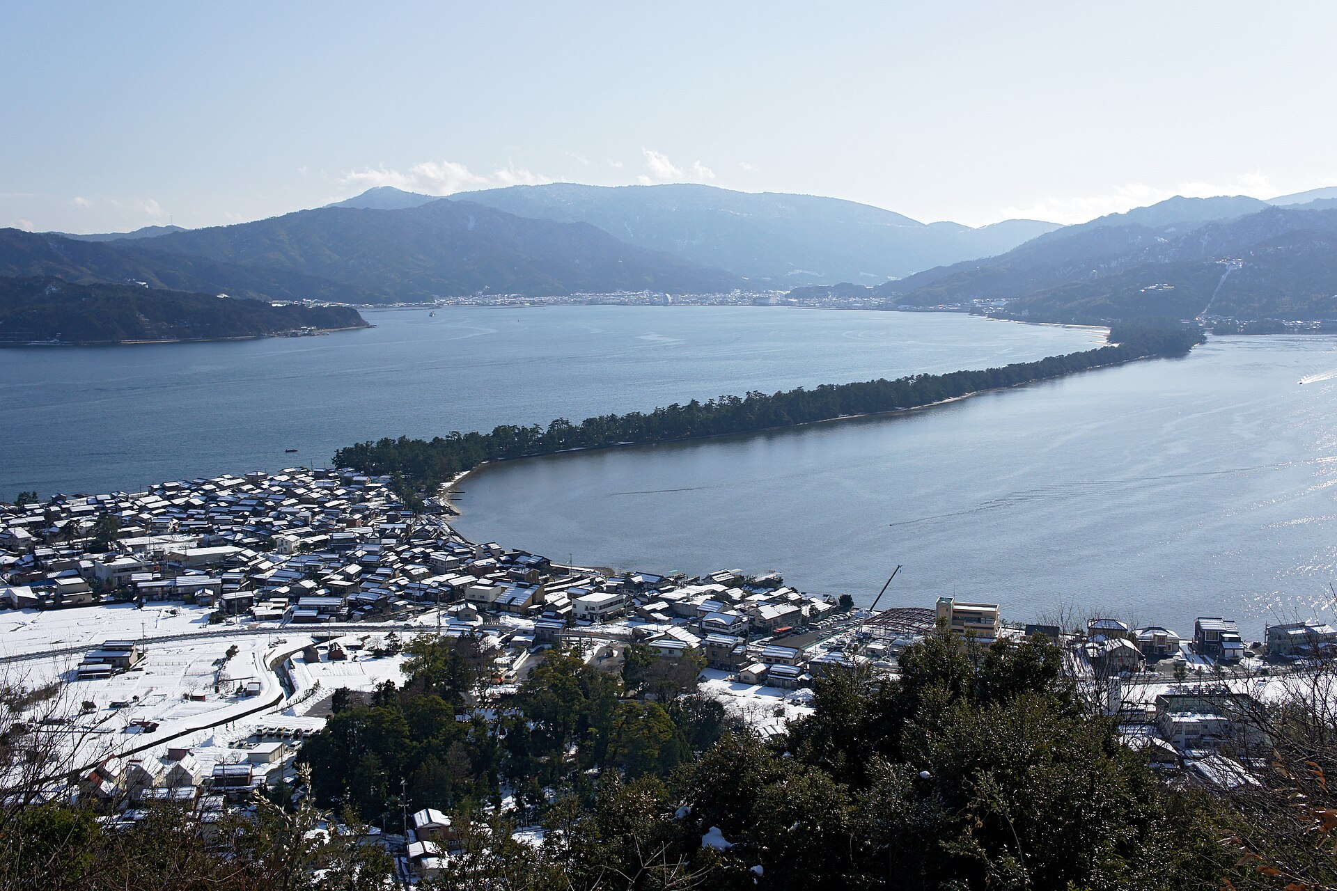 冬季從傘松公園向南俯瞰天橋立 —— 覆雪的府中地區聚落在前景，松林砂洲橫亙於阿蘇海與宮津灣之間，這就是被稱為「昇龍觀」的角度