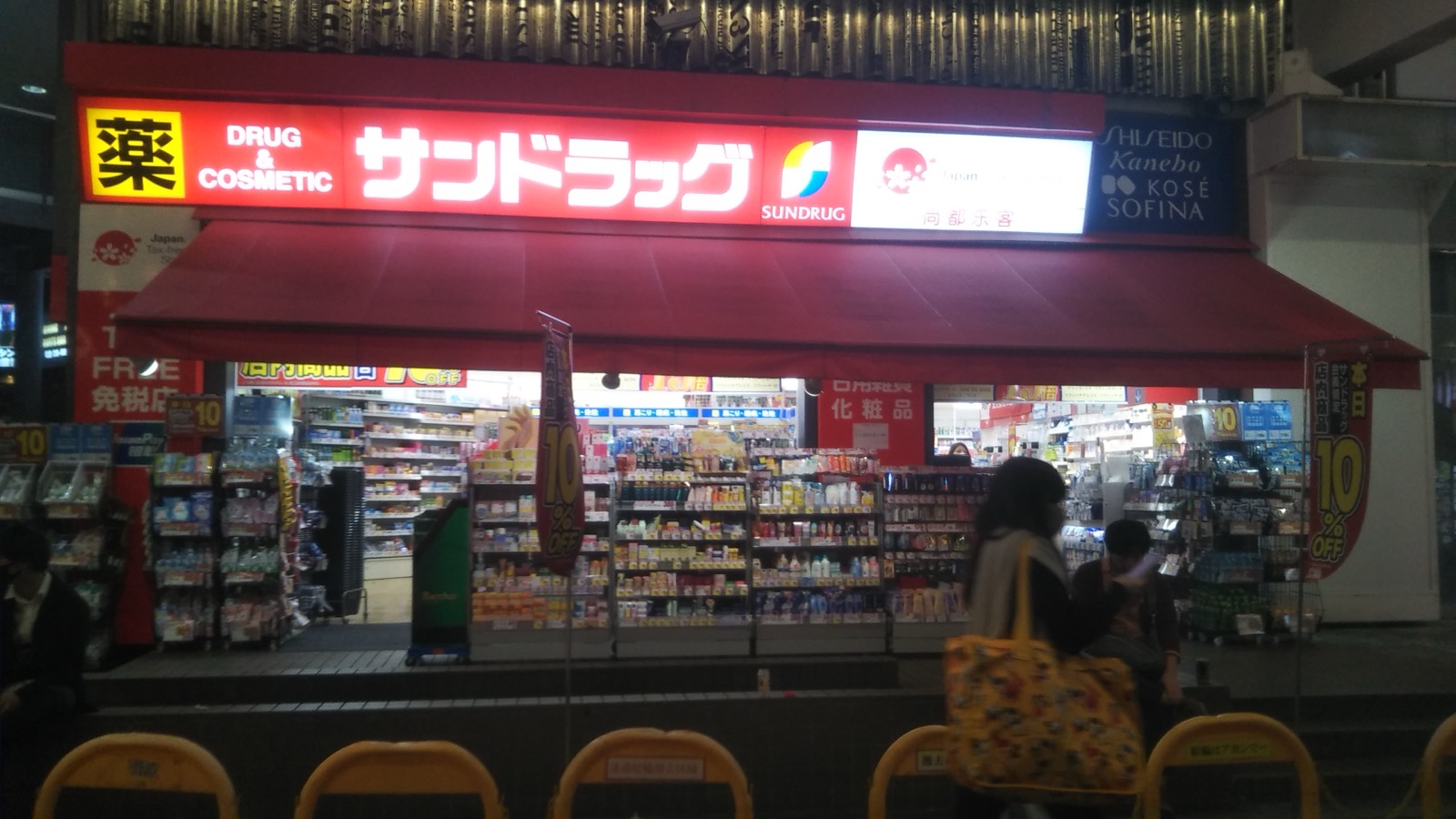 サンドラッグ（Sundrug）千日前店夜景，紅色招牌標示免稅店、SHISEIDO・Kanebo・KOSE 等化妝品品牌