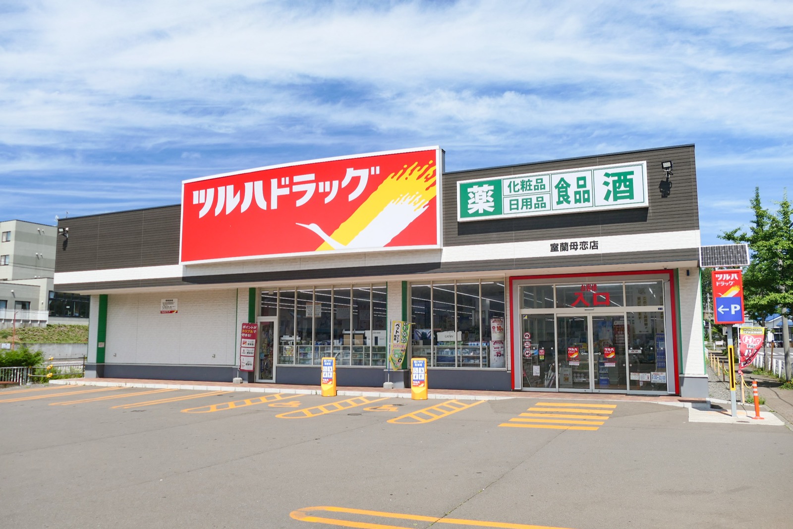 ツルハドラッグ（Tsuruha）室蘭母恋店，紅色招牌與大型停車場是郊區型店舖的典型