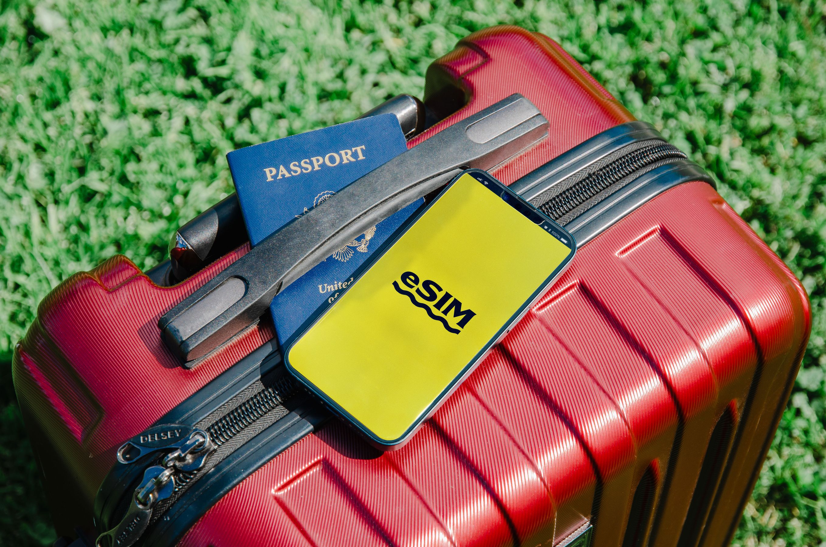 手機顯示 eSIM 畫面、護照與行李箱 — 日本旅遊行前設定 eSIM 示意