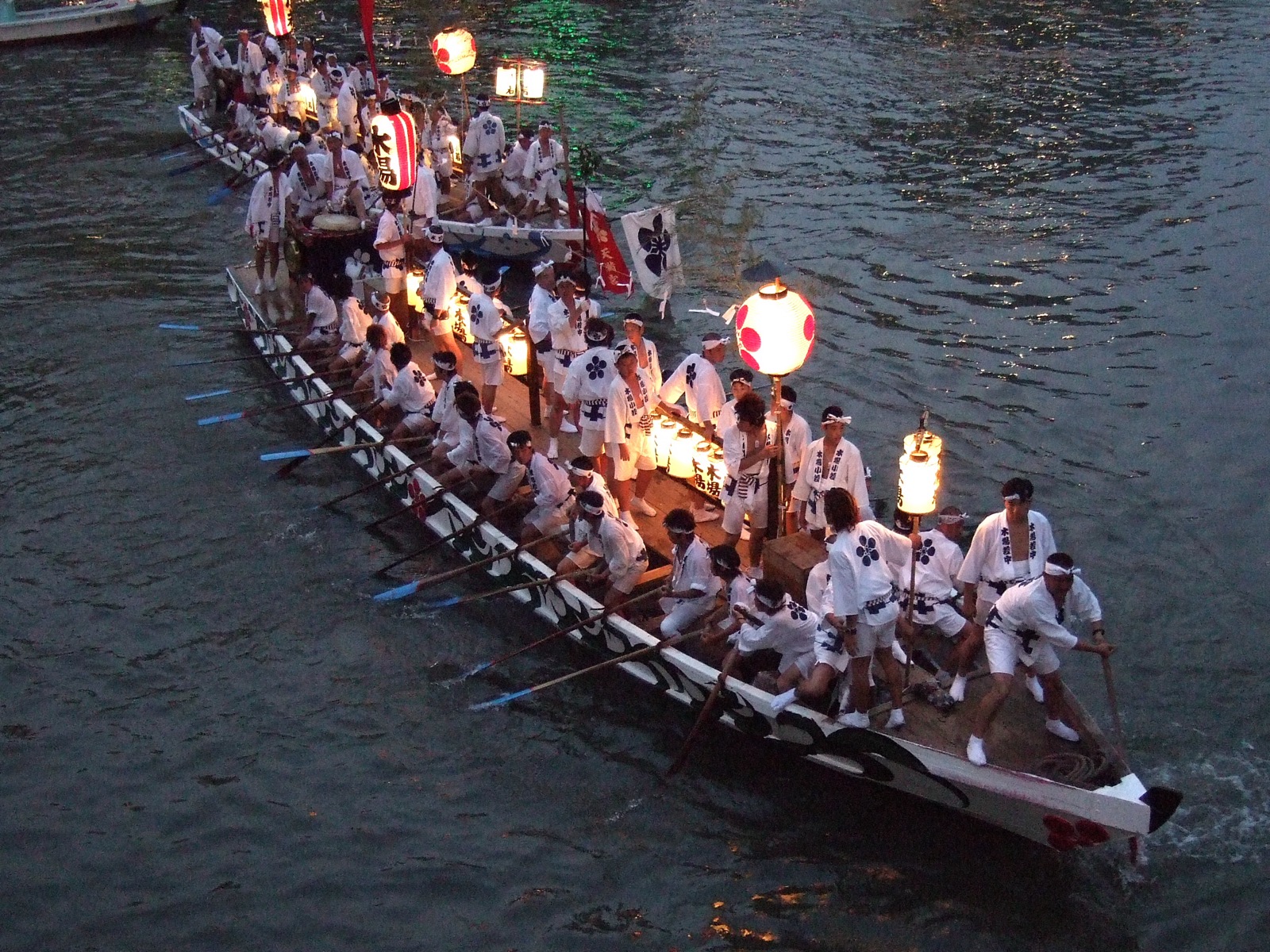 大阪天神祭本宮的船渡御（ふなとぎょ），裝飾華麗的船隻在大川上緩緩前進