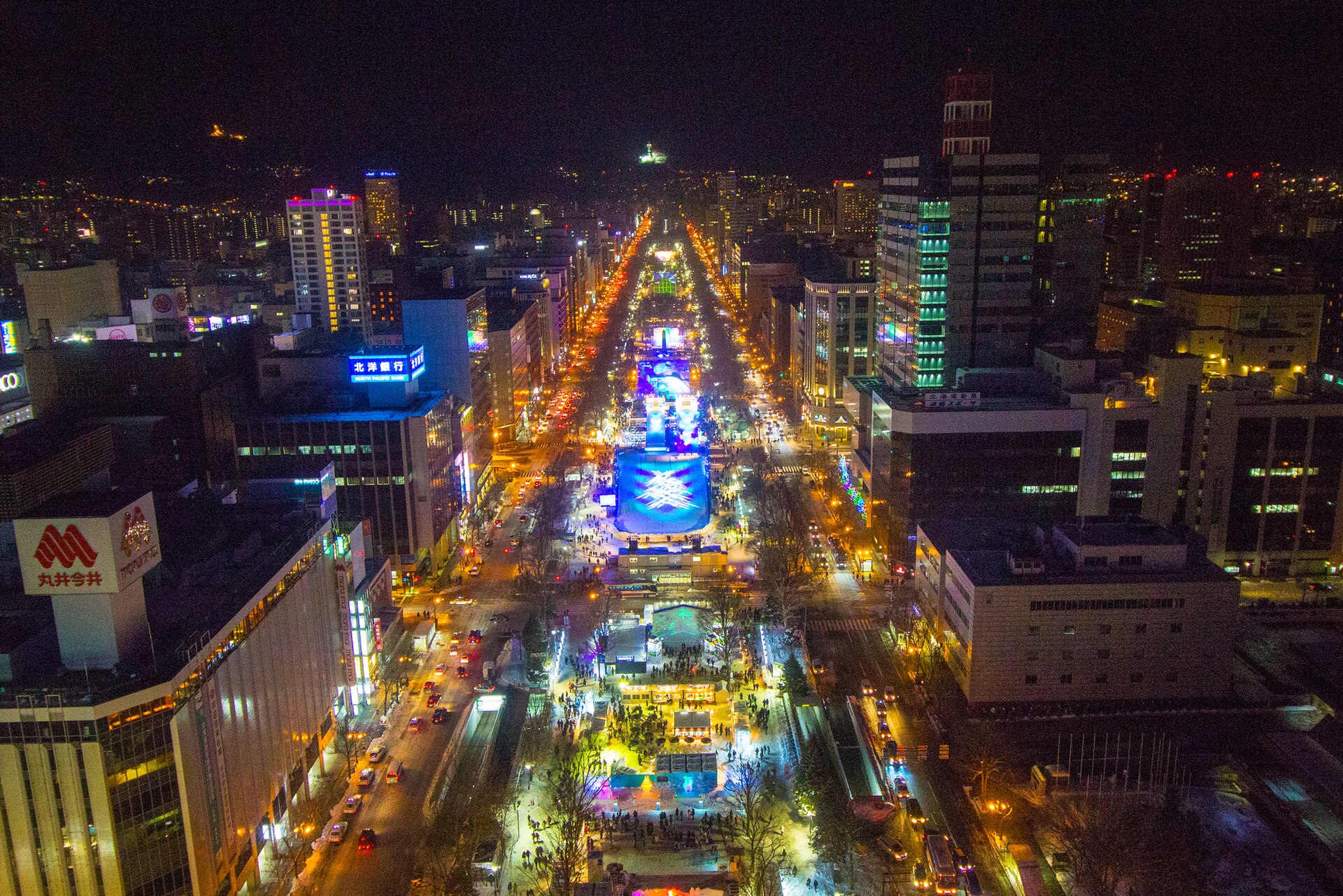 札幌大通公園夜景，電視塔與周邊大樓的燈光倒映在市中心街道上