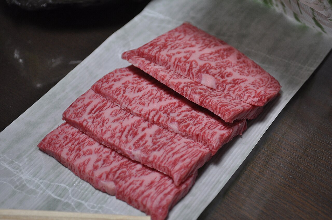 松阪牛薄切片 — 霜降均勻的松阪牛生肉片，展現頂級黑毛和牛的脂肪分布