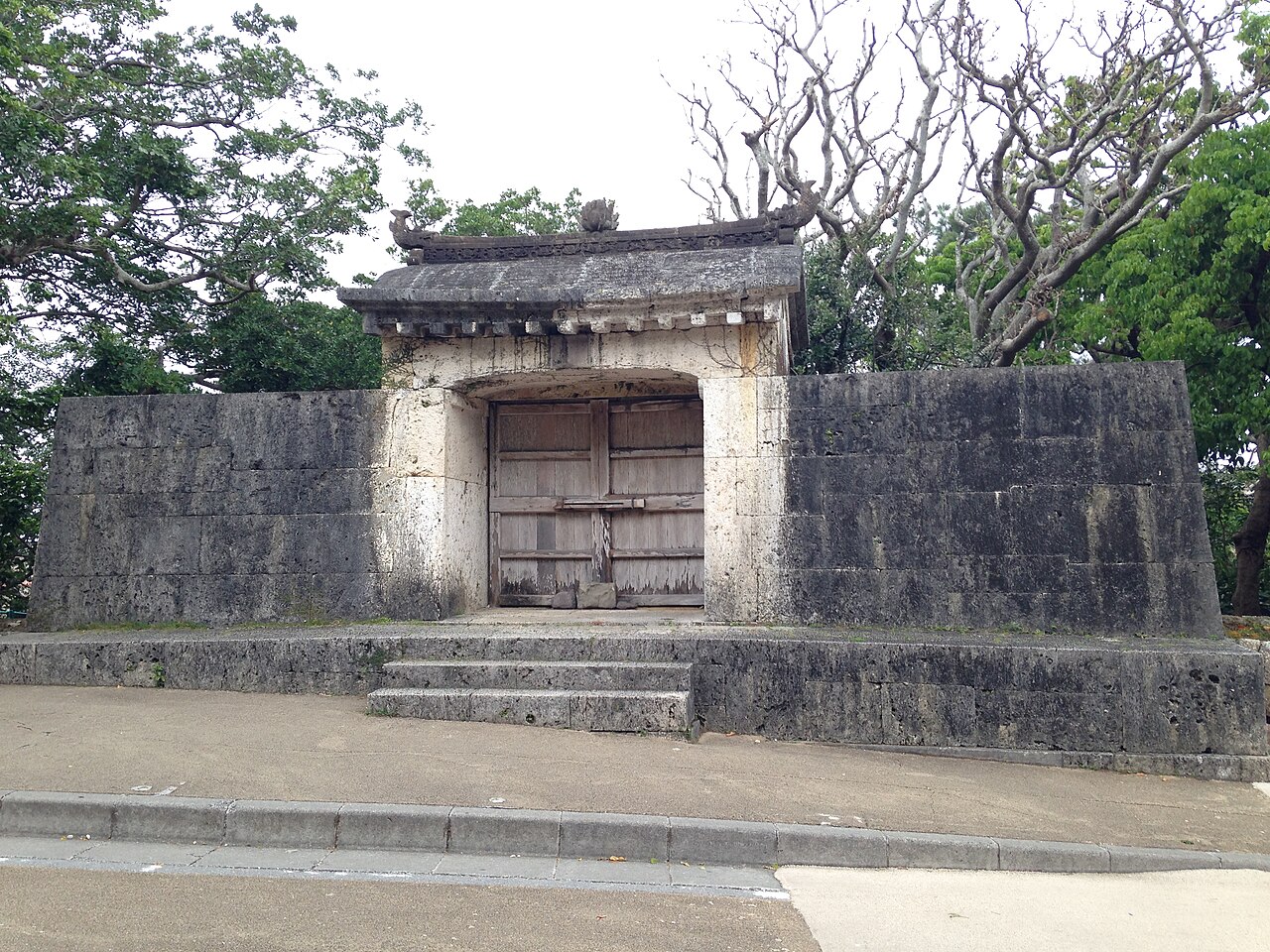 園比屋武御嶽石門 —— 石造屋頂、木製門扉與左右石牆組成的琉球石造建築