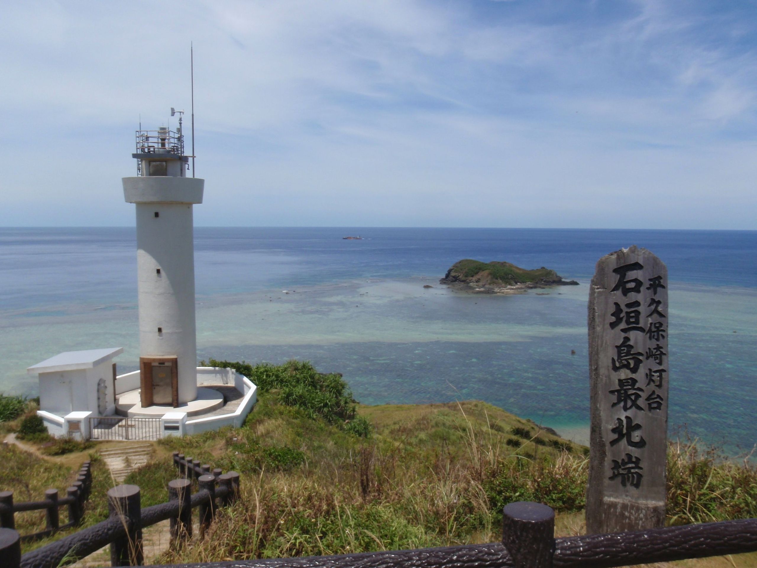 石垣島平久保崎燈塔（ひらくぼさきとうだい），位於石垣島最北端的純白燈塔，珊瑚礁形成的翡翠綠海與藍天，左為東海、右為太平洋