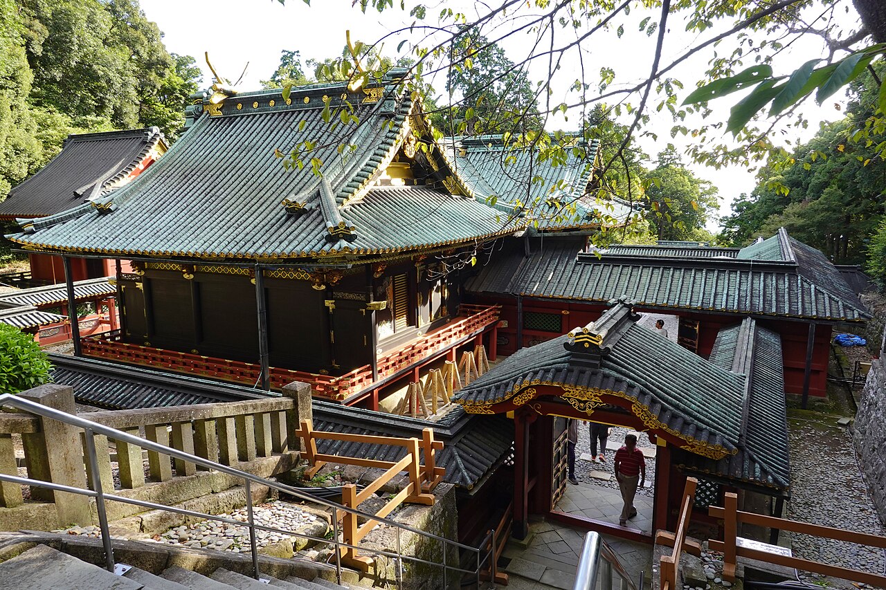久能山東照宮石造鳥居與社殿入口，豪華彩繪建築在青山中格外醒目