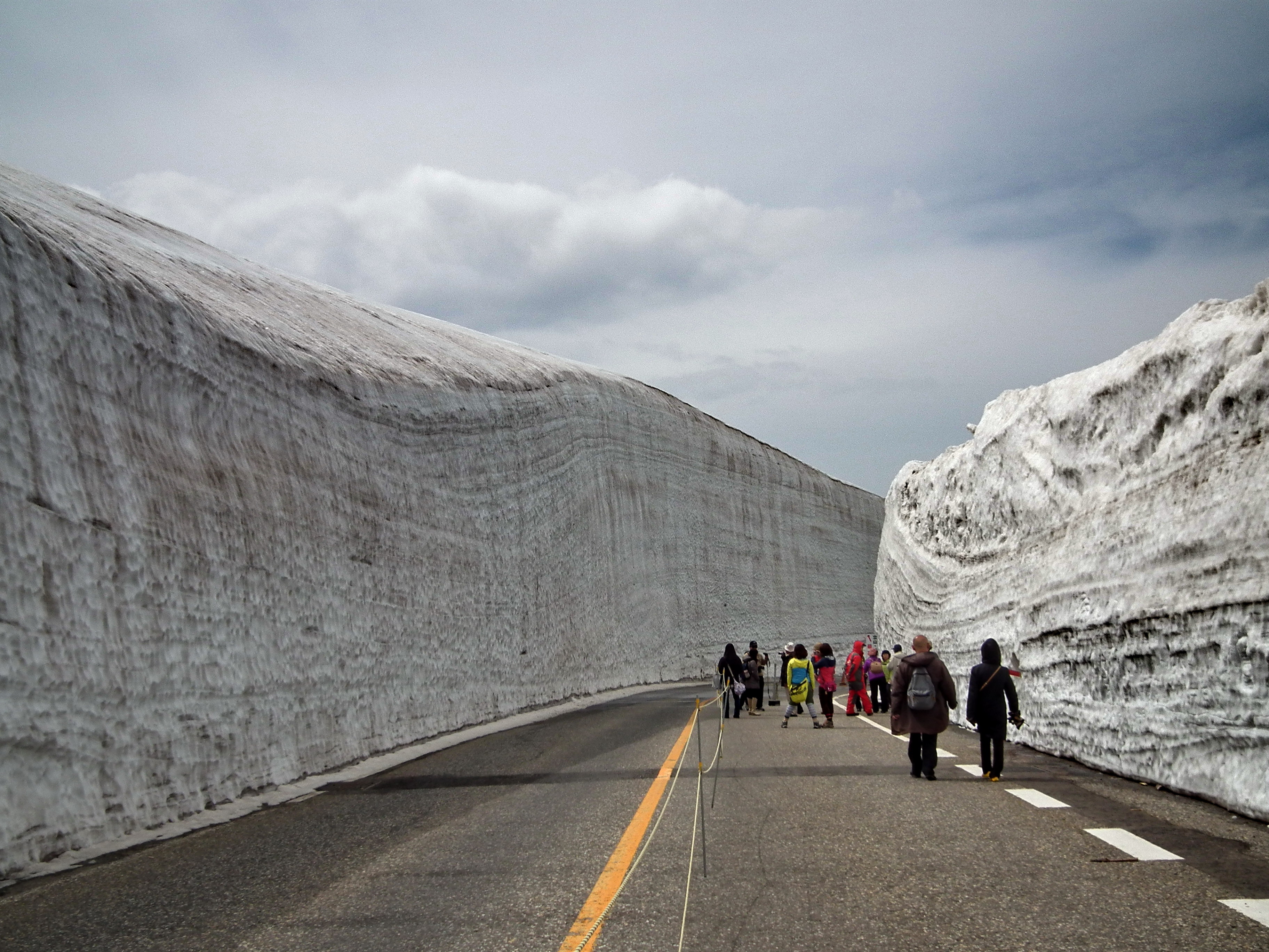 遊客走在立山黑部雪之大谷的雪壁步道間 — 春季限定的健行體驗