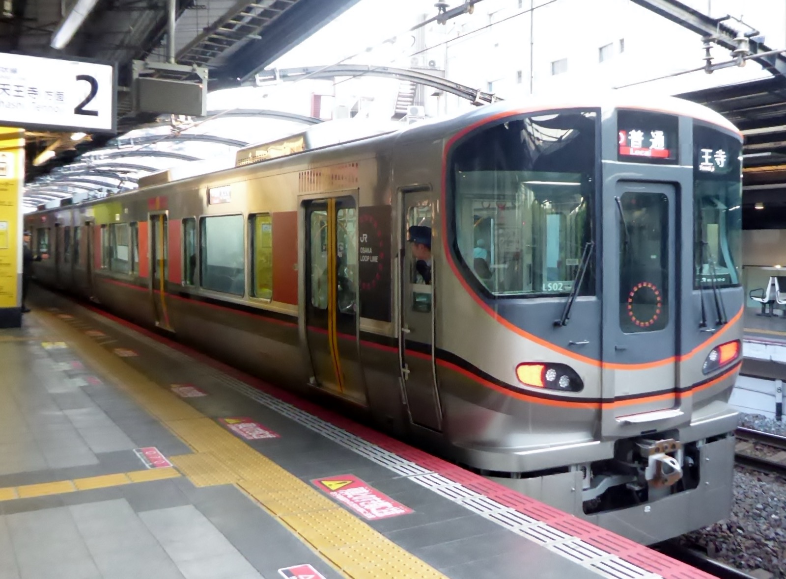 JR 西日本 323 系電車——銀色不鏽鋼車身搭配橘色飾帶的通勤型電車，行駛於大阪環狀線與夢咲線（櫻島線）